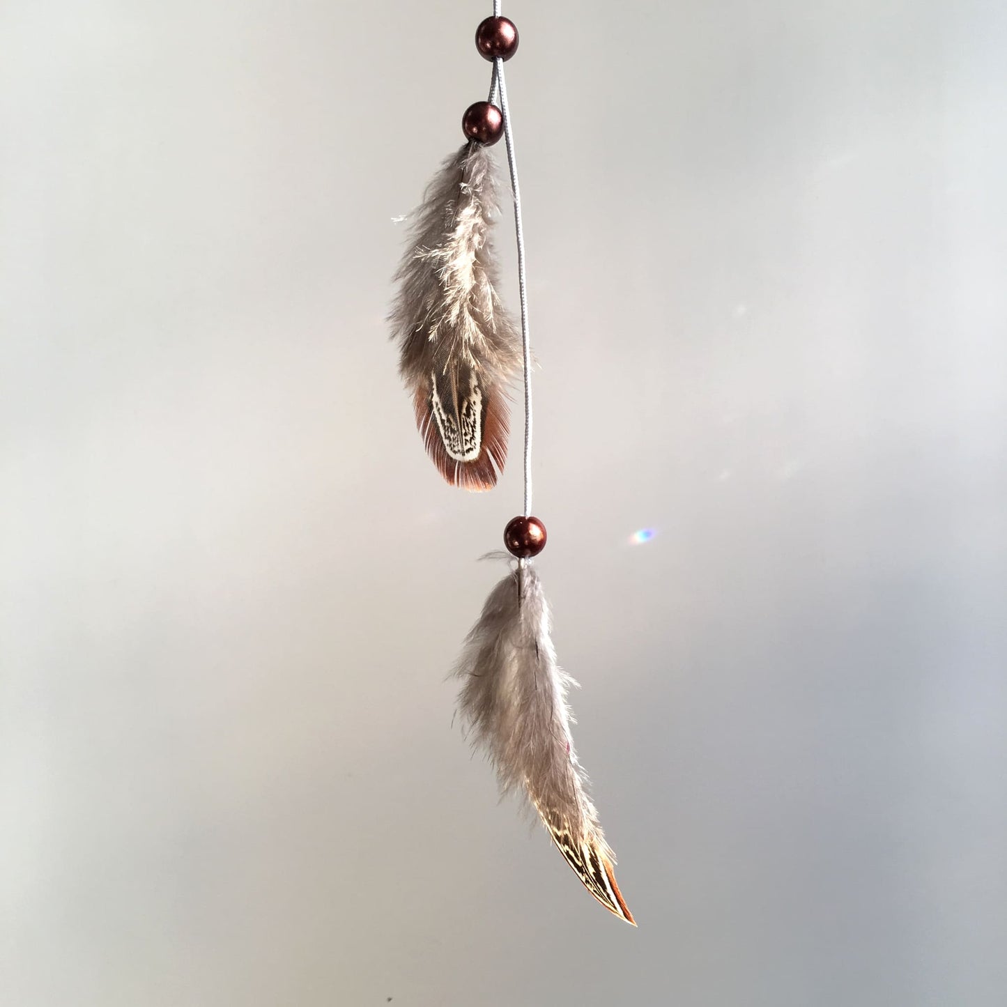 collier-sautoir de chez décoplumes composé de perles et de deux plumes - variante naturel faisan amande