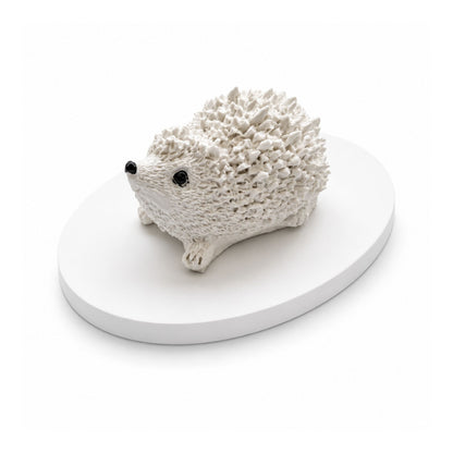 Petit hérisson décoratif blanc à parfumer en matière minérale artisanale présenté sur un plateau ovale assorti