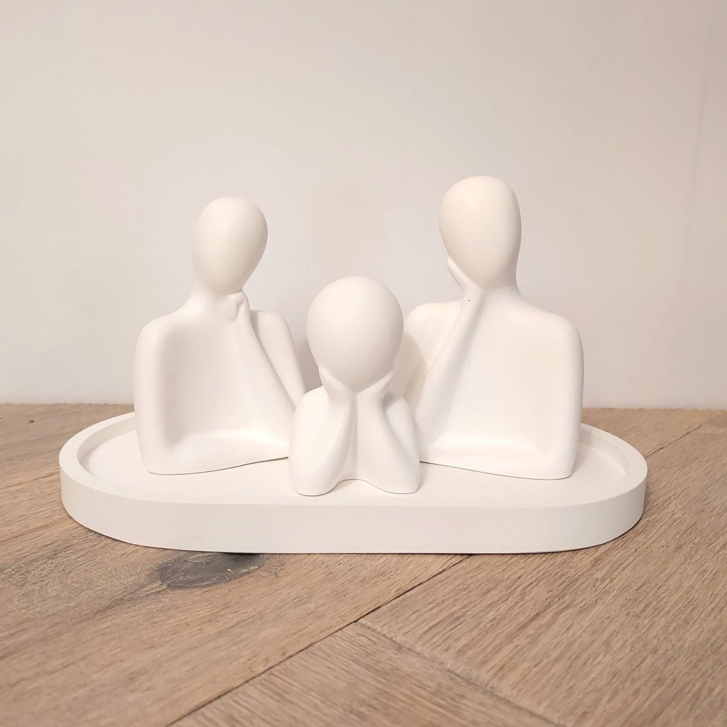 Trois figurines blanches minimalistes parfumables posées sur un plateau ovale assorti, création de Décoplumes