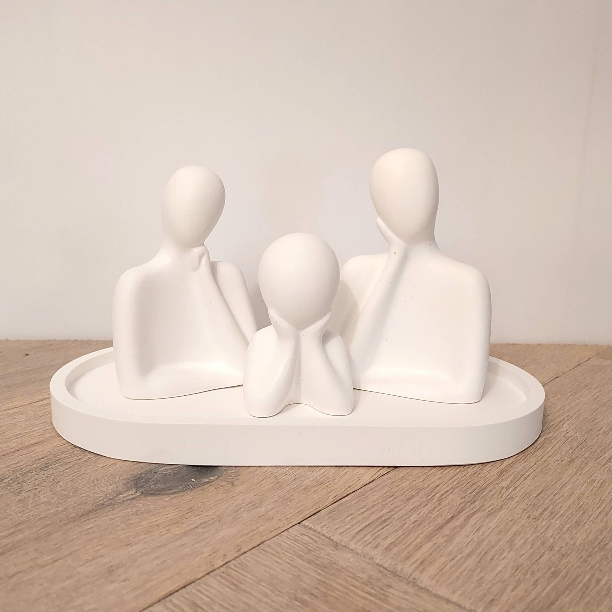 Trois figurines blanches minimalistes parfumables posées sur un plateau ovale assorti, création de Décoplumes
