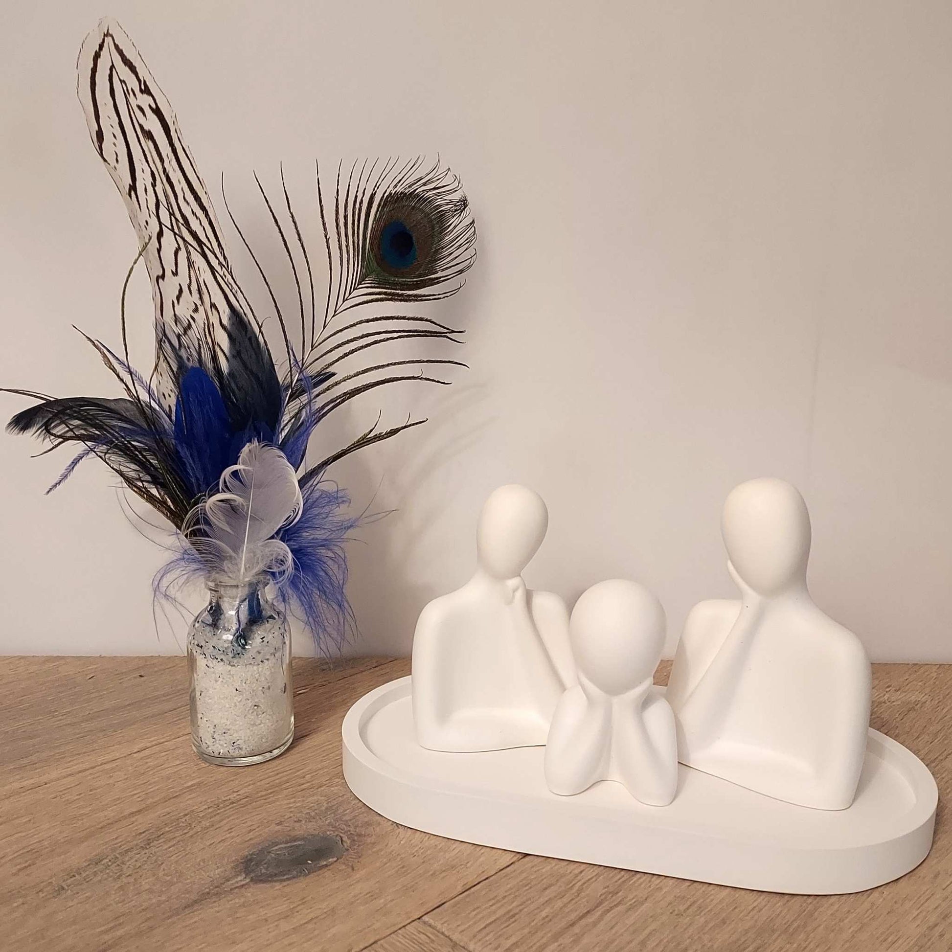 Trois figurines blanches minimalistes parfumables posées sur un plateau ovale assorti, création de Décoplumes